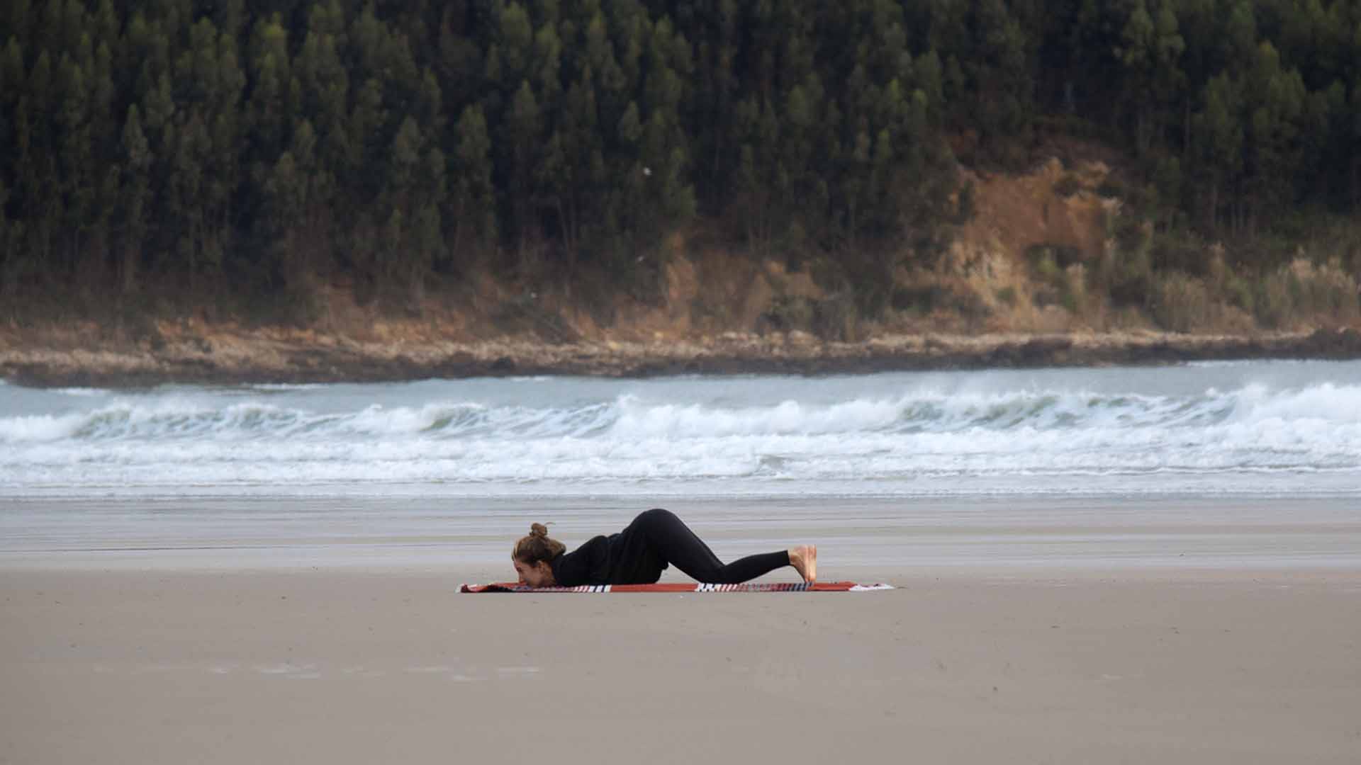 Fille sur la plage en posture de yoga ashtanga namaskar