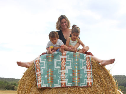 Mother with two children sitting on a bale of straw