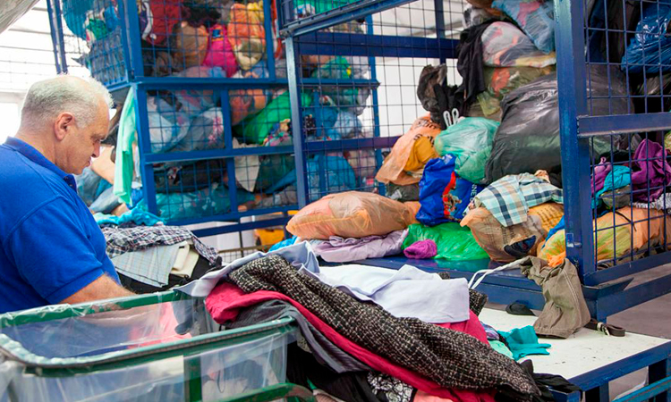 Personas trabajando en selección de textiles para reciclaje