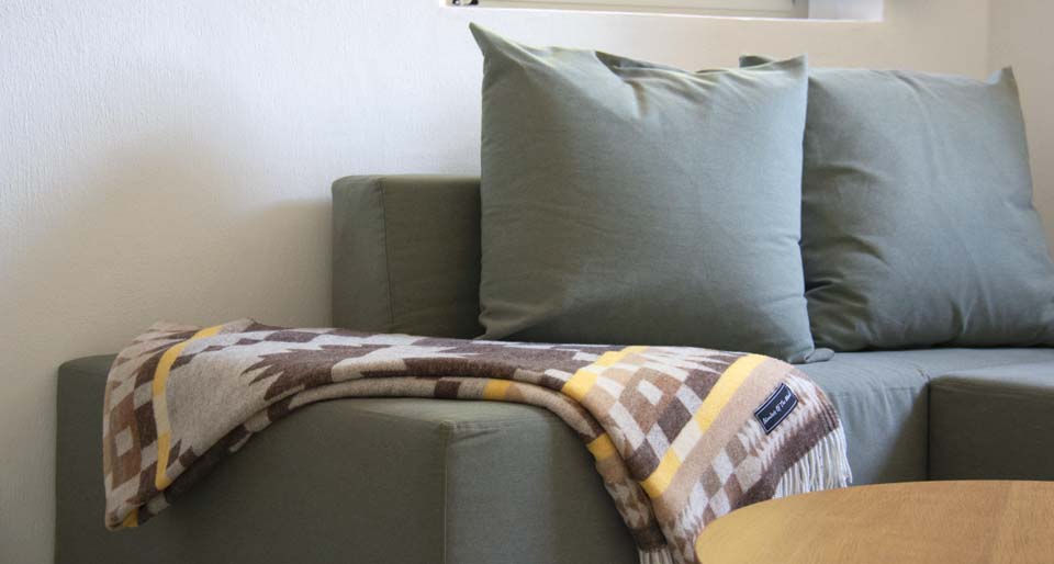 Blanket folded on a sofa.